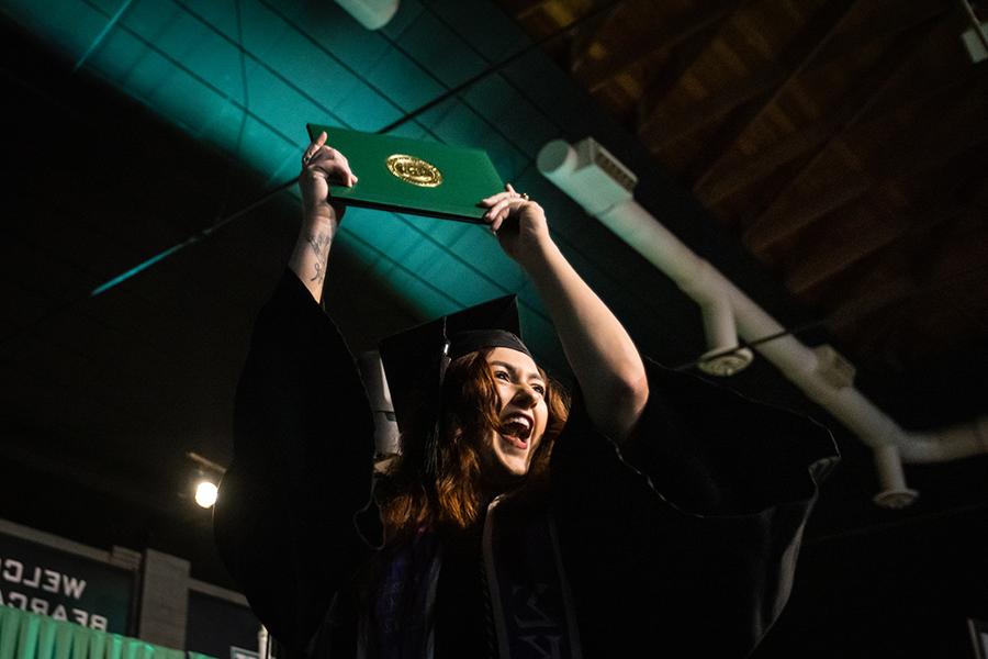 周六，<a href='http://j2ne.youfa110.com/'>澳门网上博彩官方网站</a>的一名毕业生在毕业典礼上展示她的毕业证书.